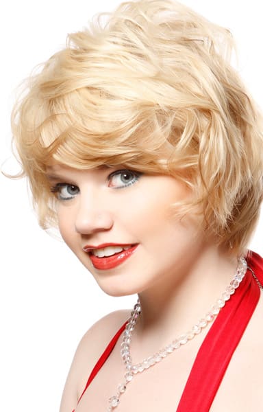 Creamy blonde hair color on long wavy pixie cut.