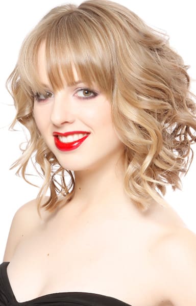 Highlighted sandy blonde hair color on a long french banged wavy lob haircut.