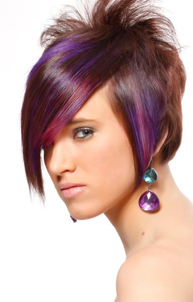 Vibrant colors of purple and pink accents auburn hair color on an a-line long layered pixie cut.