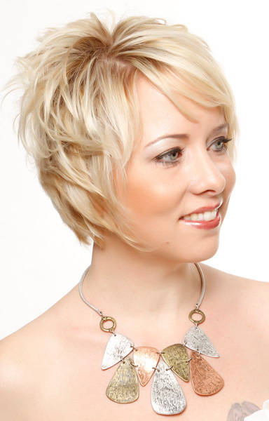 Blonde hair color and face framing medium pixie haircut with slight wavy layers.